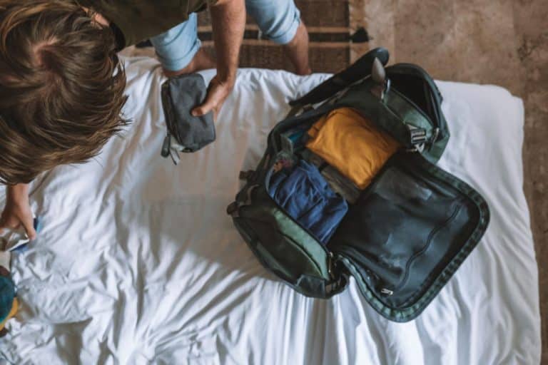 Male traveler packing clothes in a duffel bag, How To Pack A Suit In A Duffel Bag
