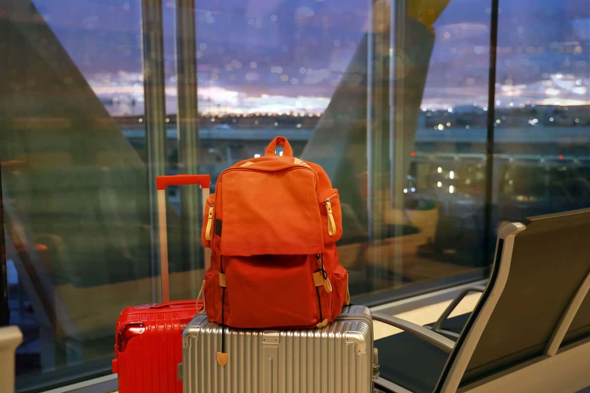 good weather to travel and a nice view to see, orange back pack gold luggage, red luggage