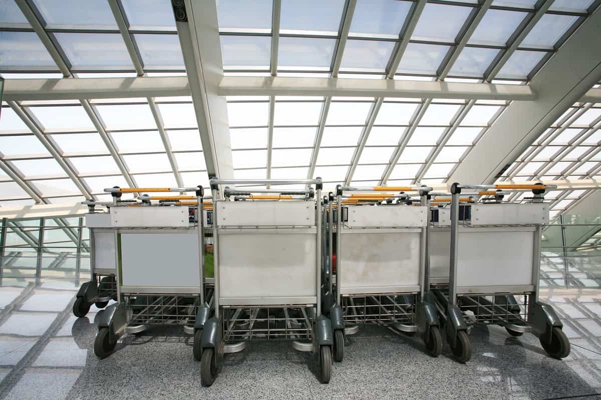 pile of luggage carts inside the airport terminal, well arranged