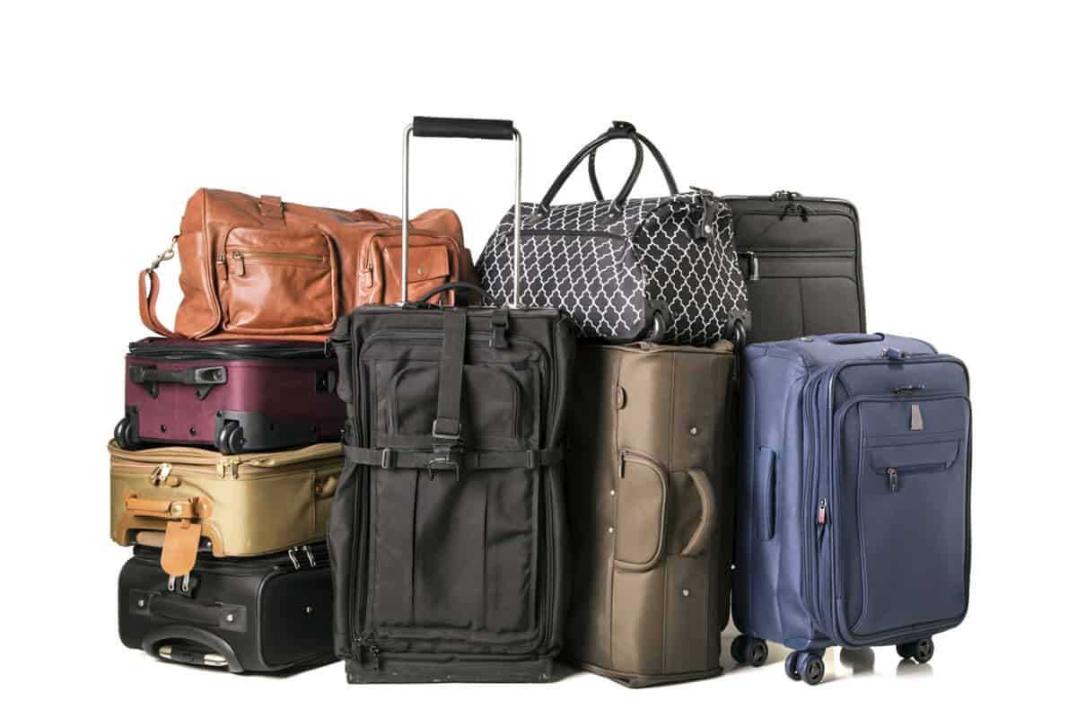 A large assortment of luggage on white background.