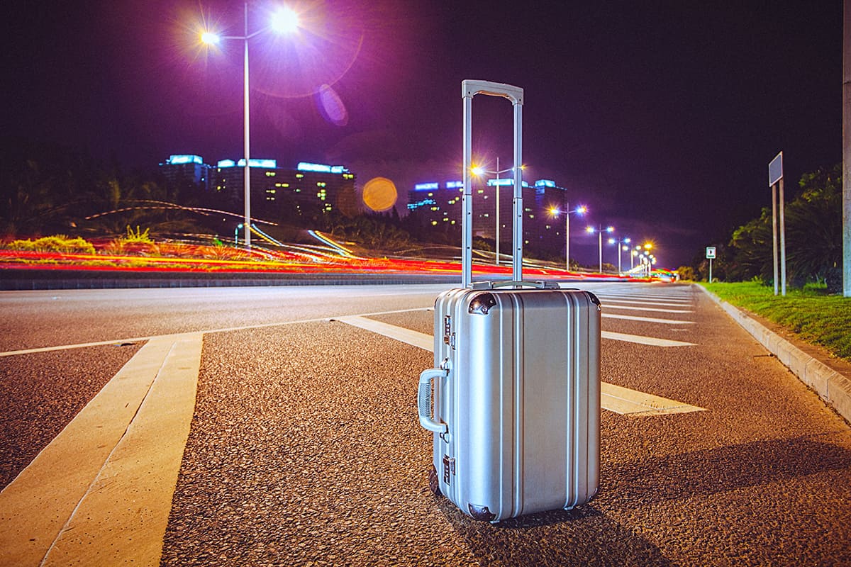 Aluminium suitcase beside the highway