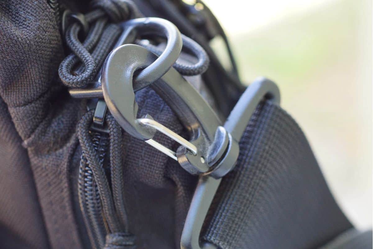 Black metal latch on a harness made of fabric on a bag.