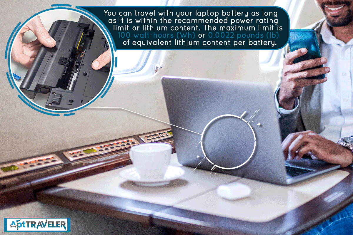 Businessman using laptop on a private jet, Can I Travel With A Laptop Battery? [Carry On Or Checked?]