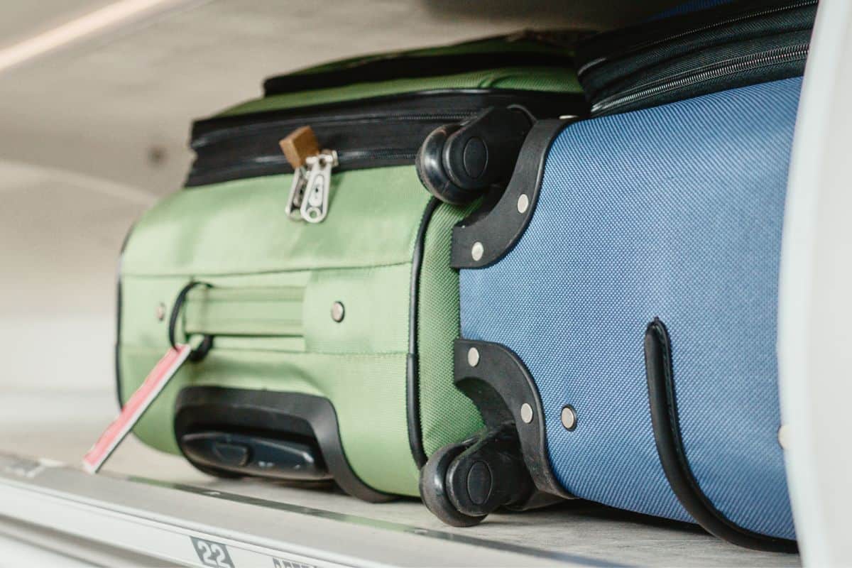 Carry-on luggages in overhead compartment of plane for international flights. Travel restrictions during coronavirus not allowing hand baggage inside airplane.
