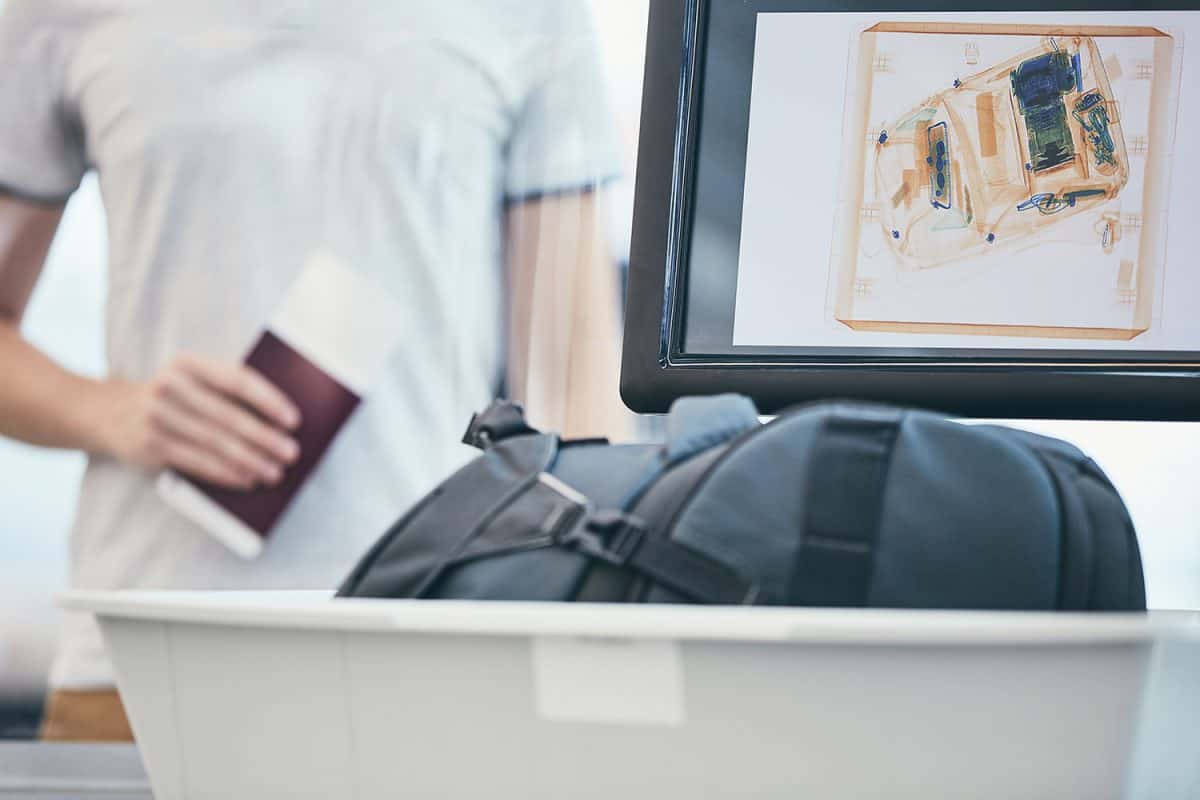 Man holding passport and waiting for x-ray control his luggage