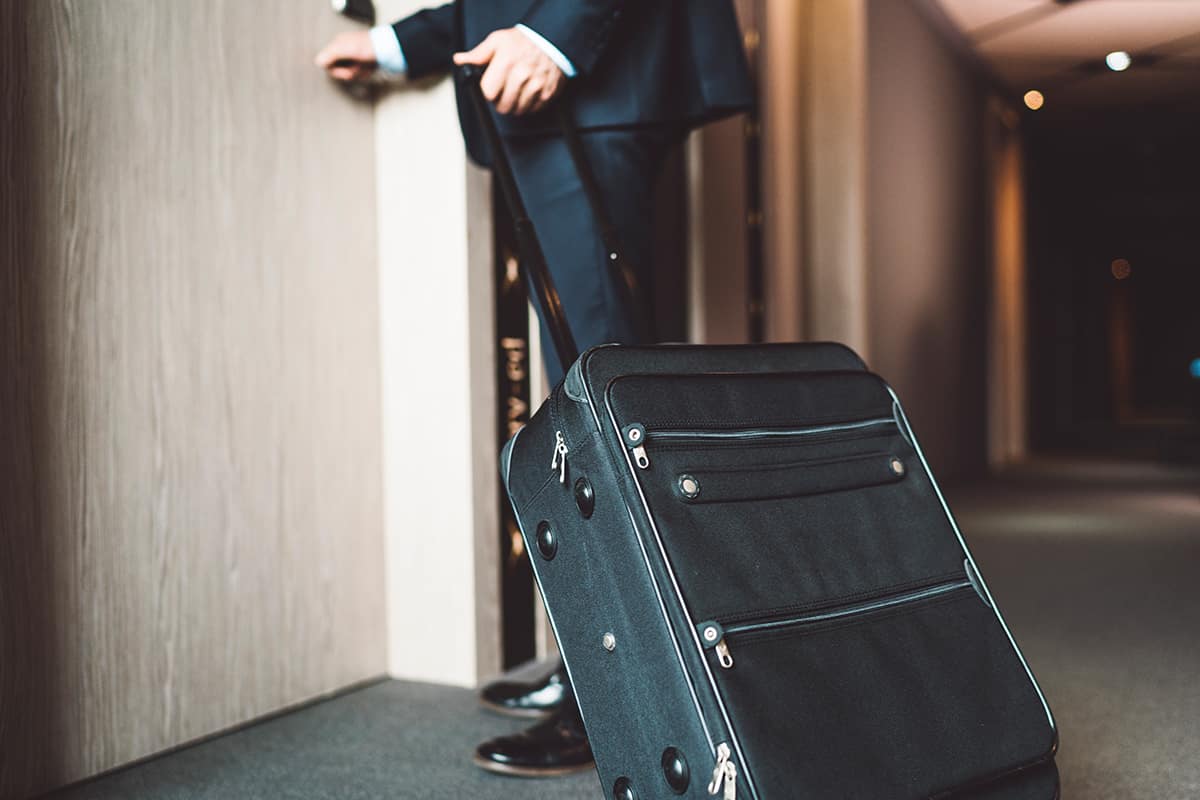 Man with a black suitcase going to his hotel room