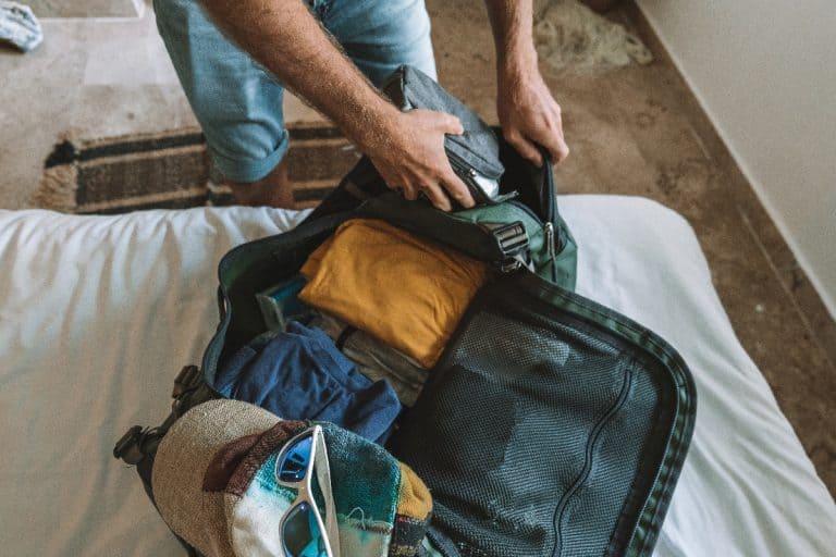 Traveler packing clothes in a duffel bag, How To Open Black Hole Duffel Bag