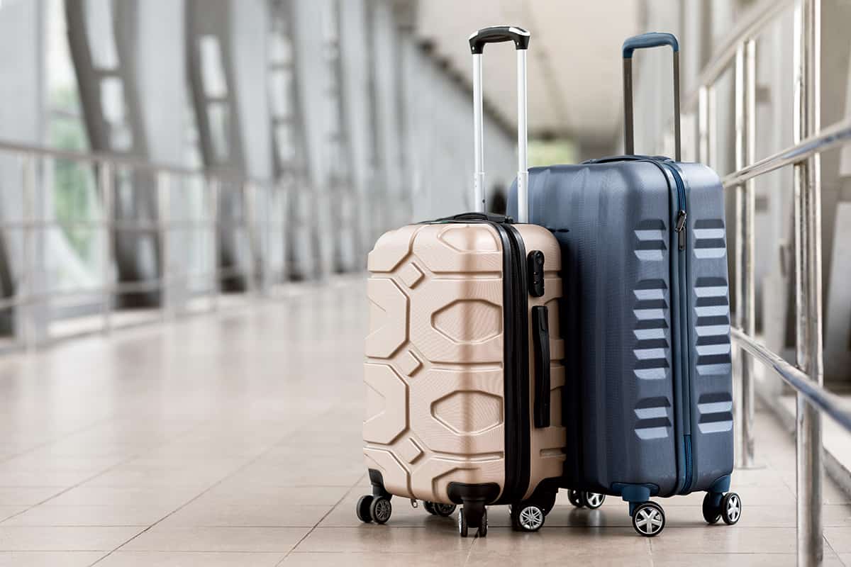 Two plastic suitcases standing at rmpty airport corridor
