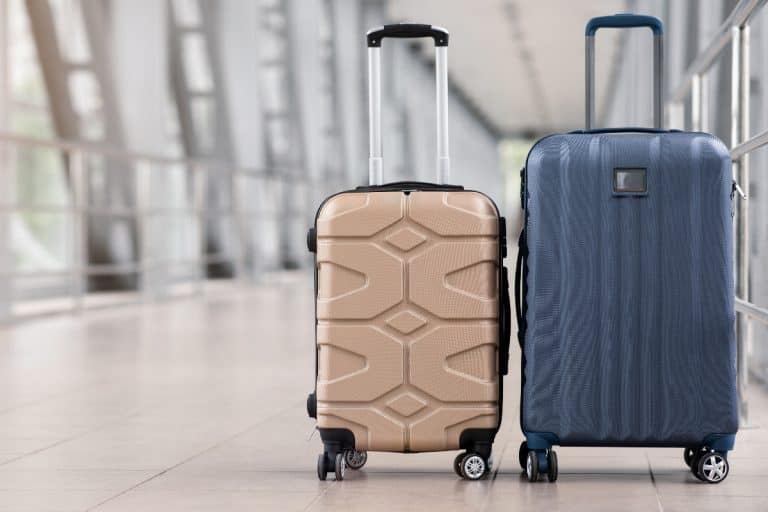 Two stylish suitcases standing in empty airport hall, Can Suitcases Be Dry Cleaned?