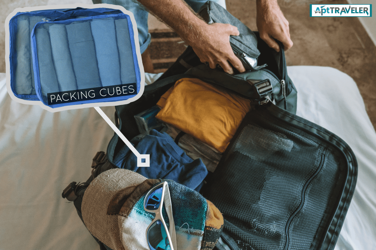 photo of a man wearing shorts, packing clothes and personal stuffs on the luggage on the bed room, Using Packing Cubes In A Duffel Bag - How To