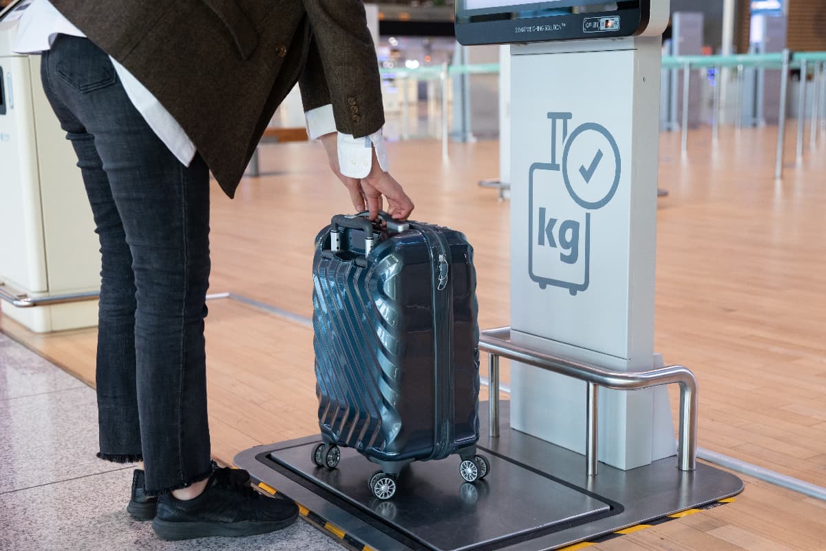 Weighing a luggage using a luggage measuring device at the airport