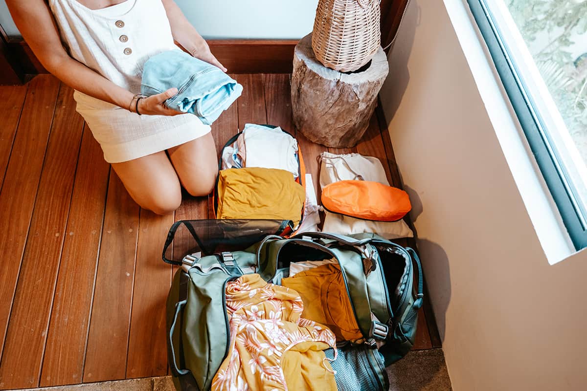 Woman packs her clothing neat and organised in individual bags