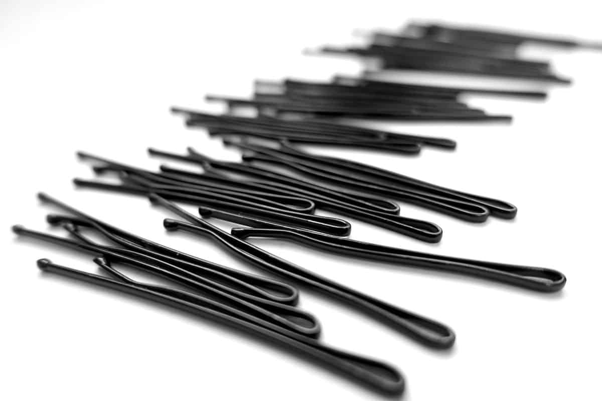 a close up photo of a black bobby pins with white background on it