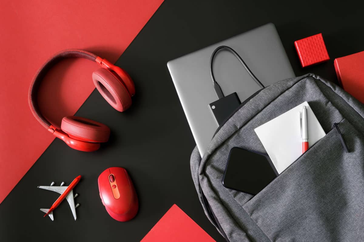 captured photo of a personal items, backpack, headphone, toy plane, laptop, mouse