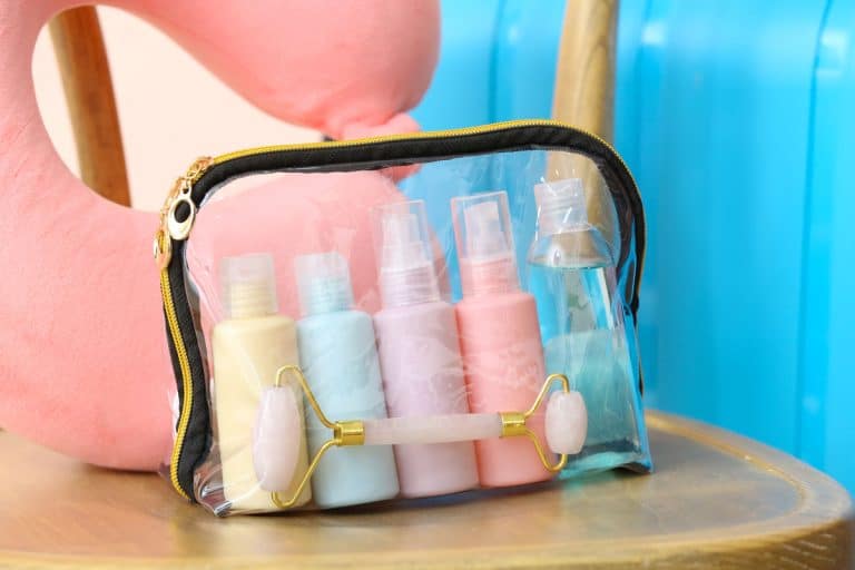 clear bag of cosmetics, colorful plastic container inside, pink neck pillow, What Is The TSA Approved Cosmetic Bag Size