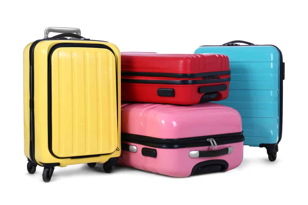 landscape photo of a yellow luggage, red luggage, pink luggage, sky blue luggage on a white background