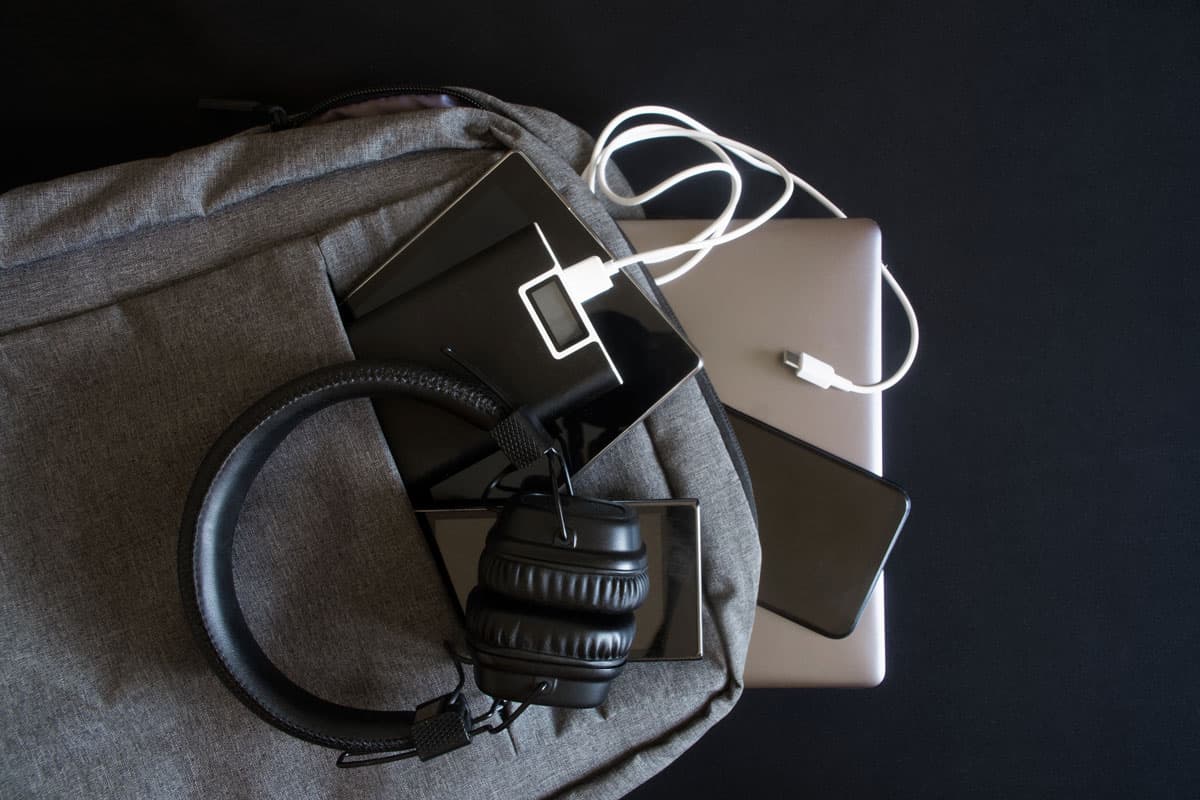 personal things and stuffs, black background, headphones, laptop,wallet, smartphone, backpack