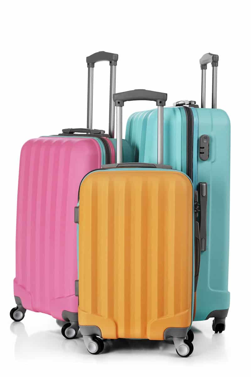 portrait photo of a pink luggage, yellow luggage and mint green luggage