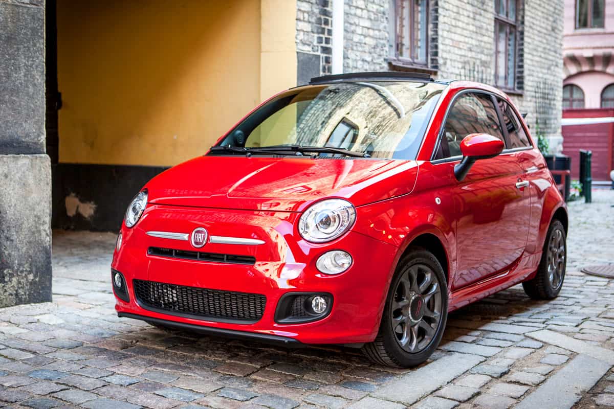 shiny red painted fiat 500 car, on the marketplace parking