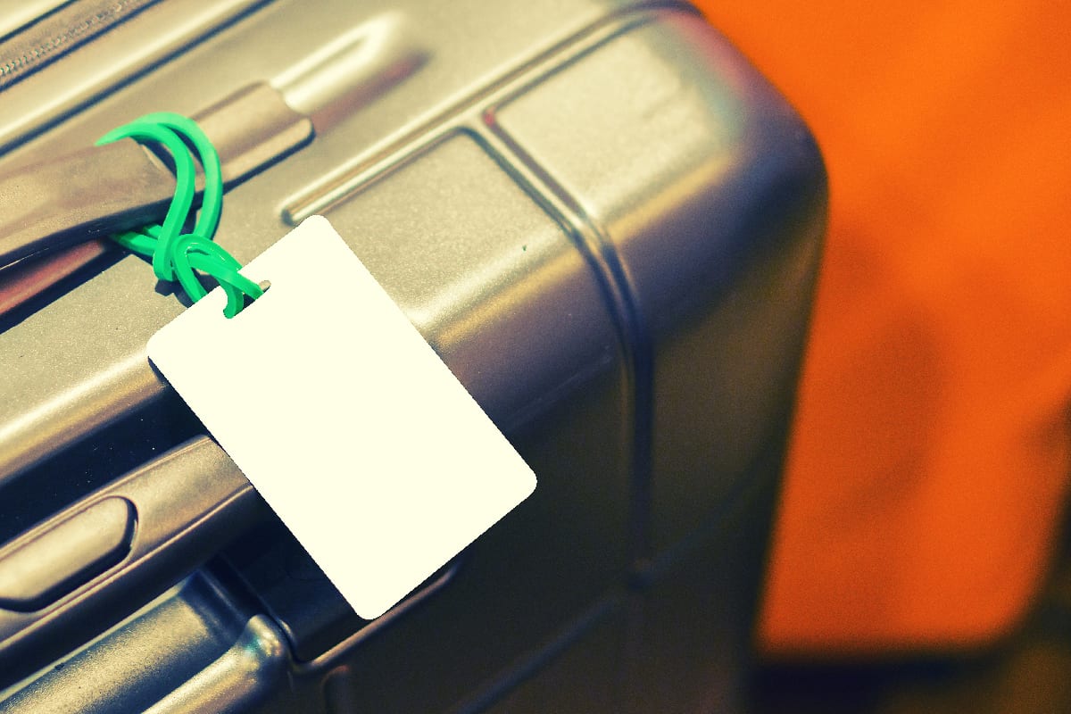 Blank luggage tag label on suitcase
