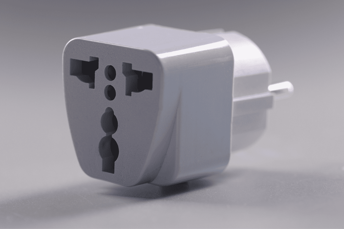 Close-up of universal white plugs adapter, adapter to put in sockets. Multi plug travel size power adapter. Charge, energy, electricity, connector concept

