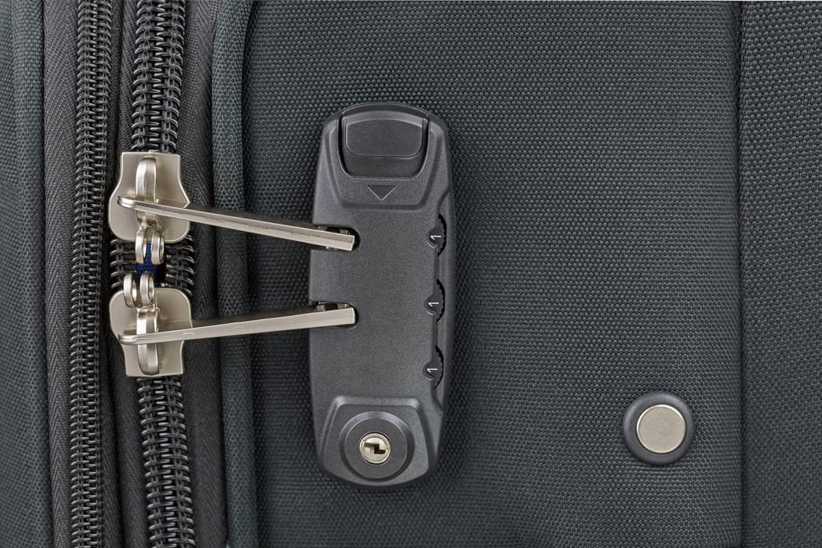Closeup top view of zipper of fabric suitcase with built in luggage lock, new and clean luggage in black color