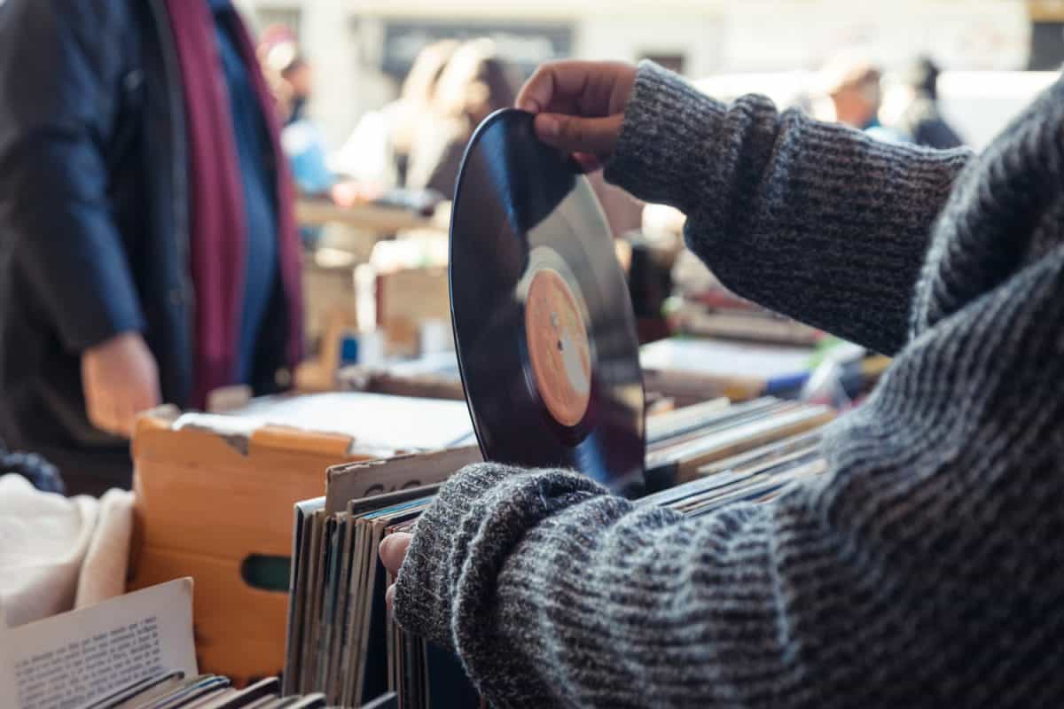 Customer browsing vybyl discs at a vintage flea market.

