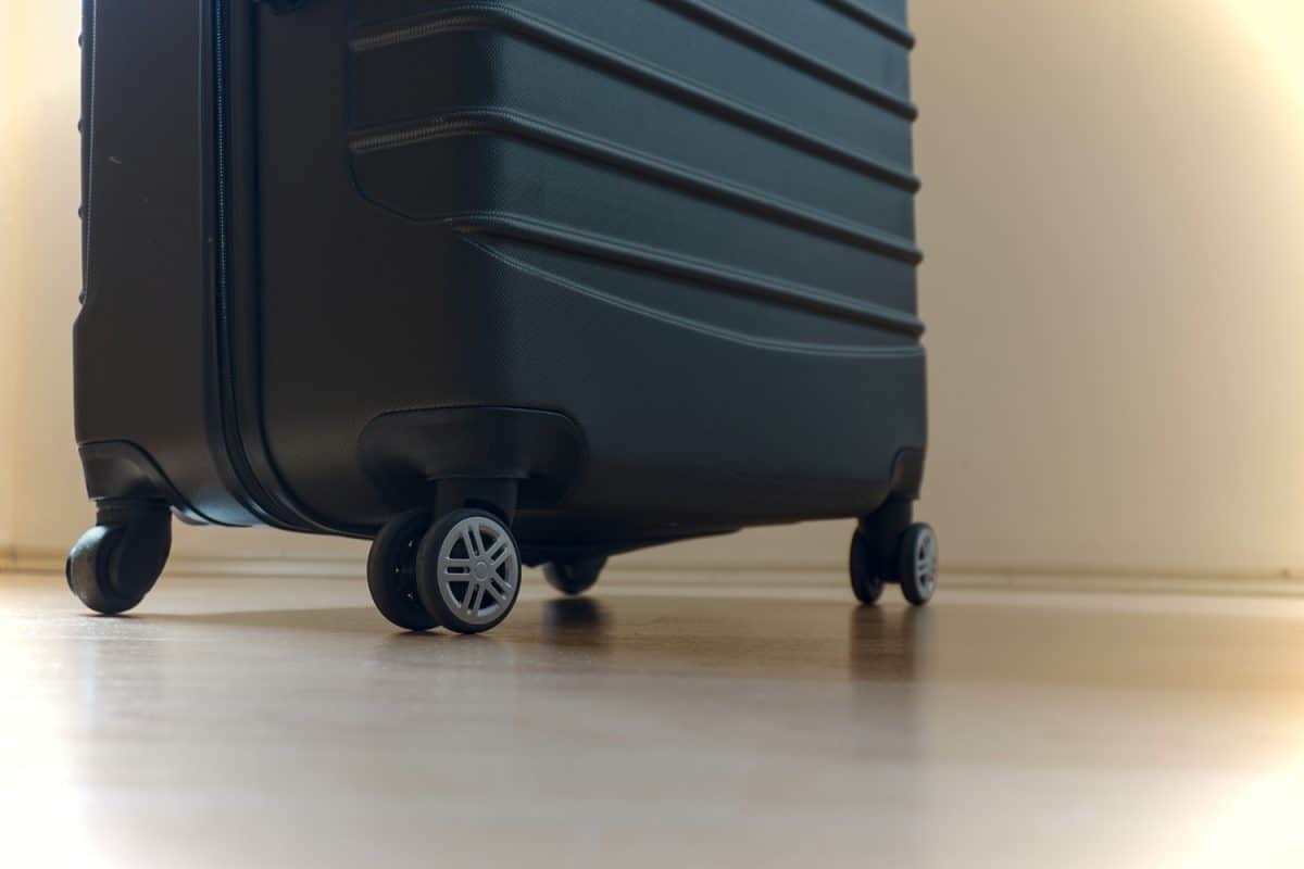 Luggage standing on wooden house parquet floor before travel.

