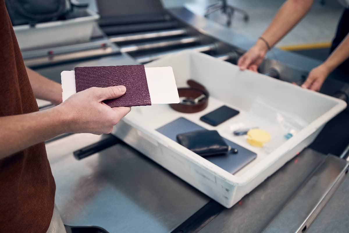 Man holding passport at airport security check