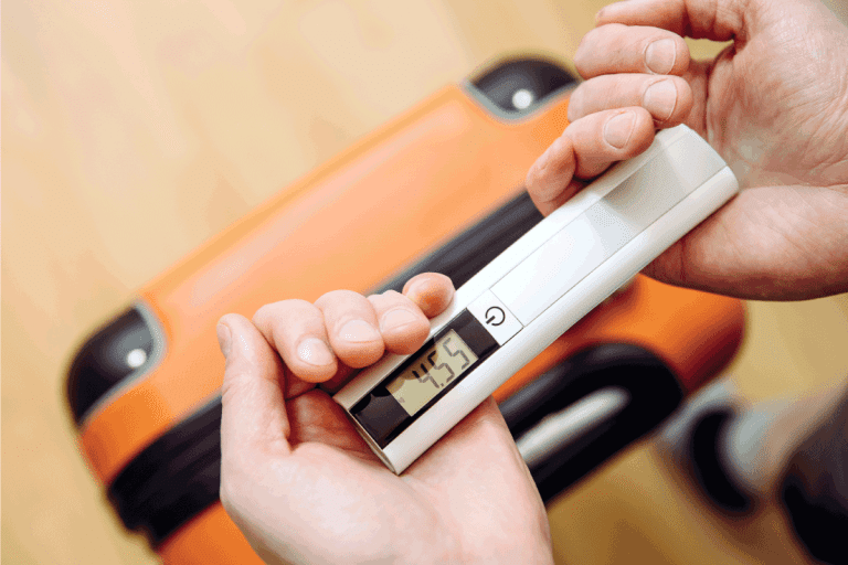 Man tourist using digital luggage scale at home to weighs luggage. How To Change Luggage Scale To Lbs