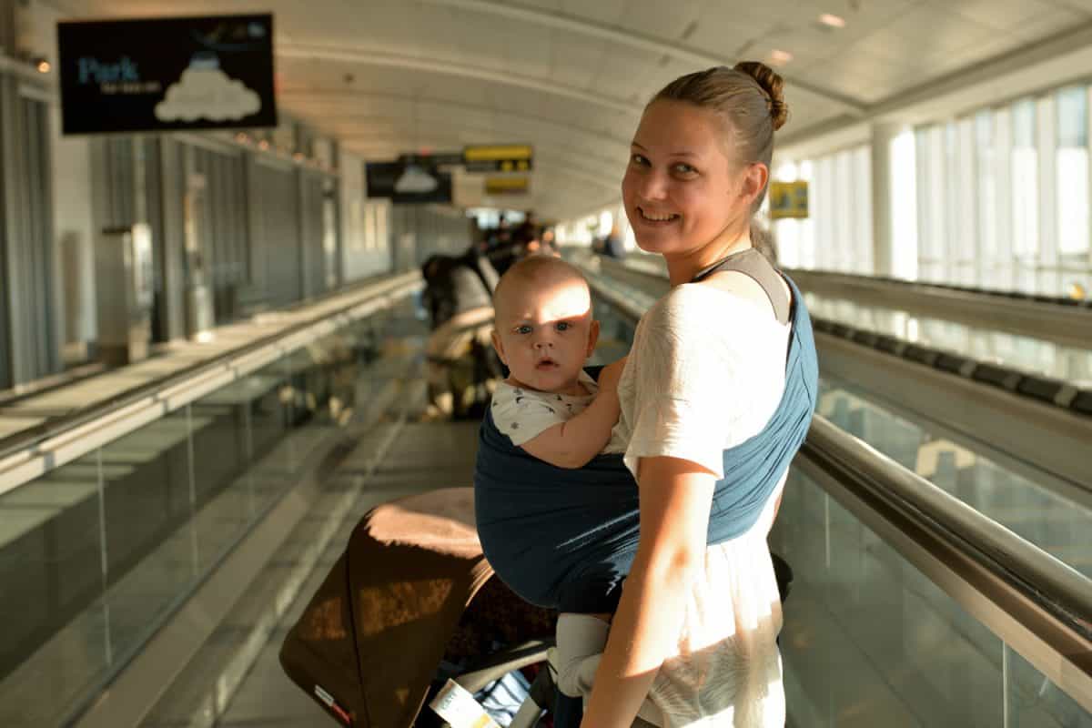 Mom and a baby on the moving walkway in airport
