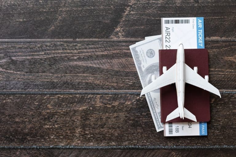 Toy airplane, Air Ticket, credit cards, dollars and passport on wooden table, What Is The Cash Limit To Carry On International Flights?