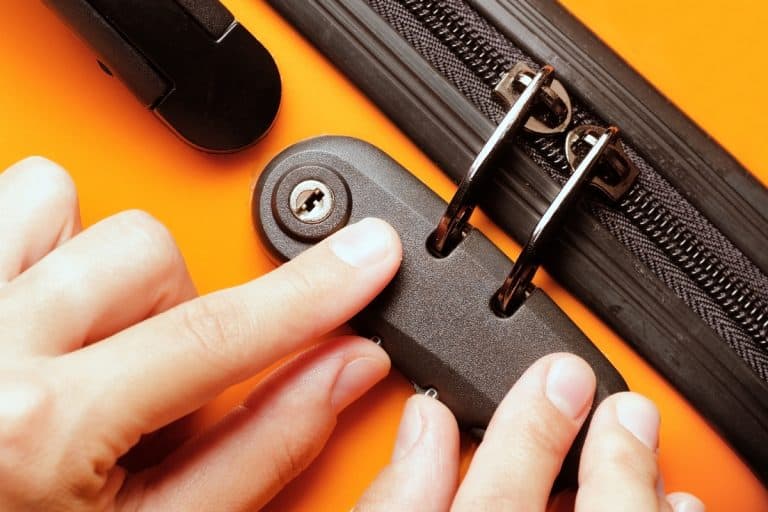 Woman locked her luggage in the orange suitcase, American Tourister Reset Button Stuck - What To Do?