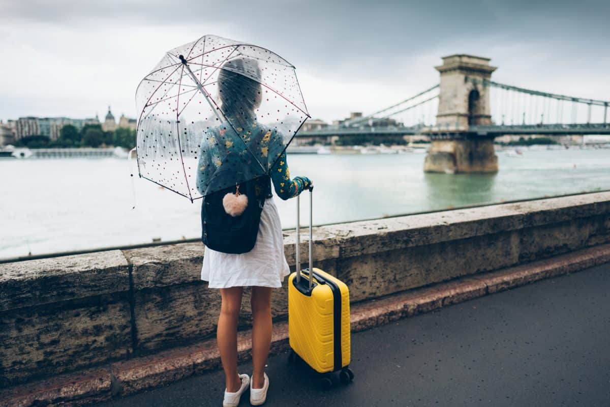 Woman with umbrella and suitcase just arriving in Budapest

