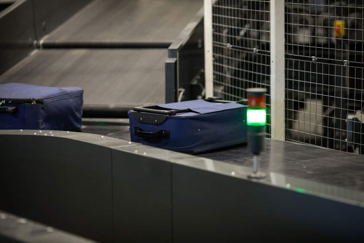 photo of a Baggage on a conveyor belt inside a luggage sorting system at an airport