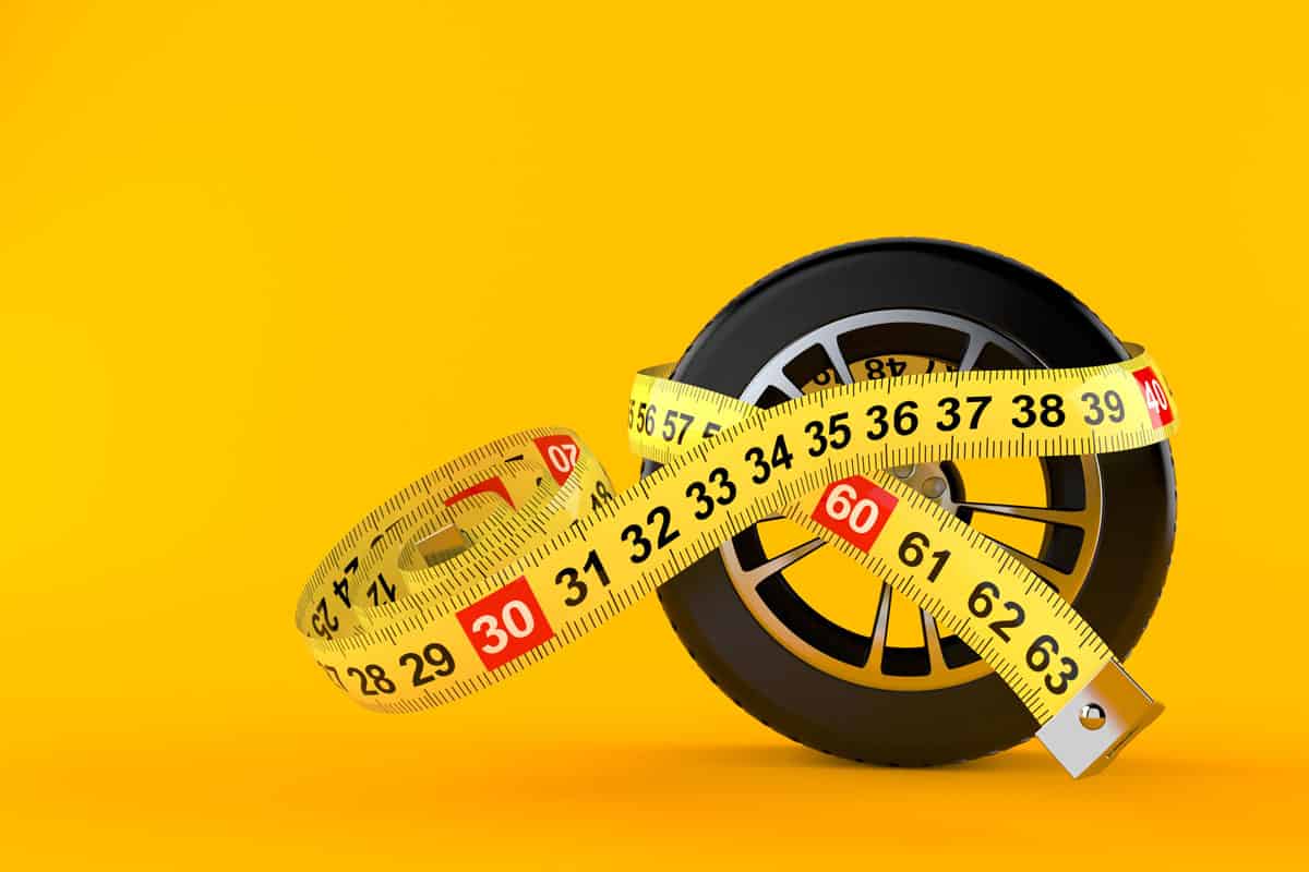 car wheel and measuring tape with centimeter with yellow background 