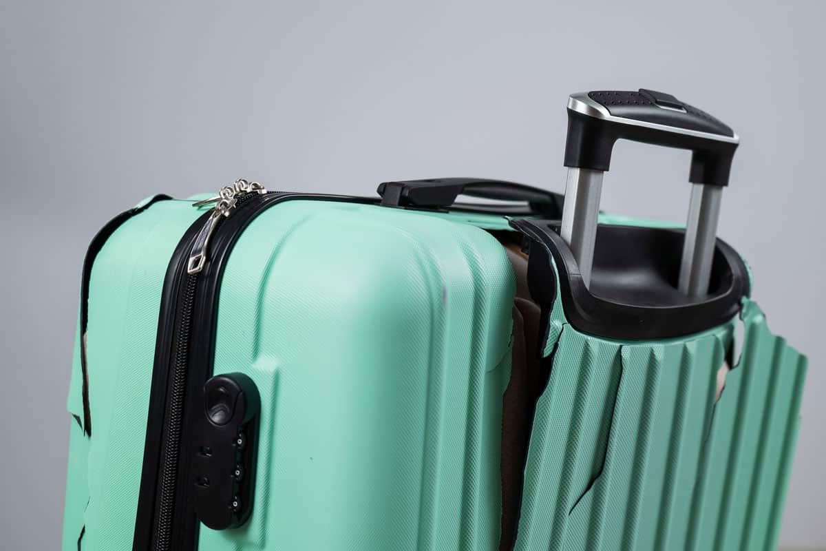 photo of a Close-up of a broken plastic suitcase on a white background