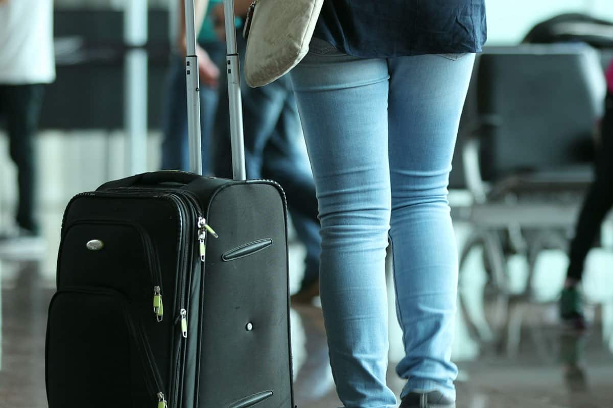 photo of a person-pulls-suitcase-airport-woman-carrying
