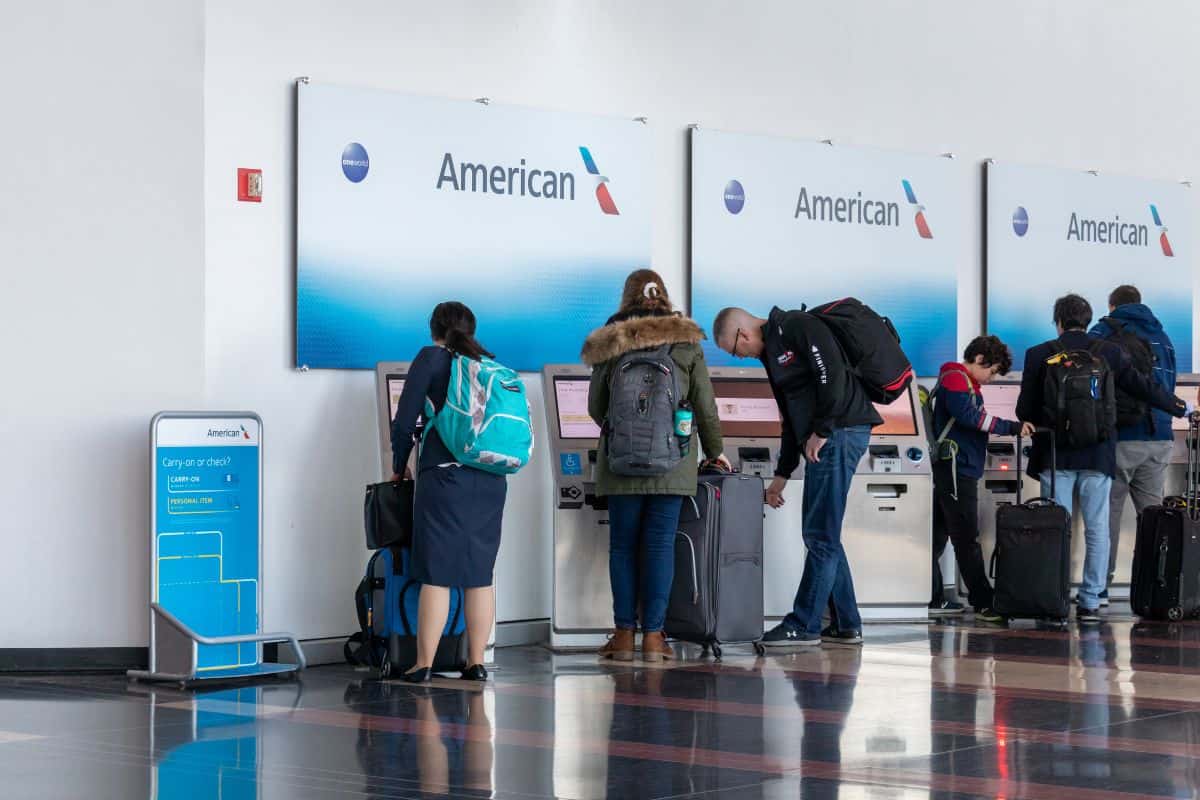  People are seen using self-serve check-in kiosks for American Airlines inside Ronald Reagan Washington National Airport.
