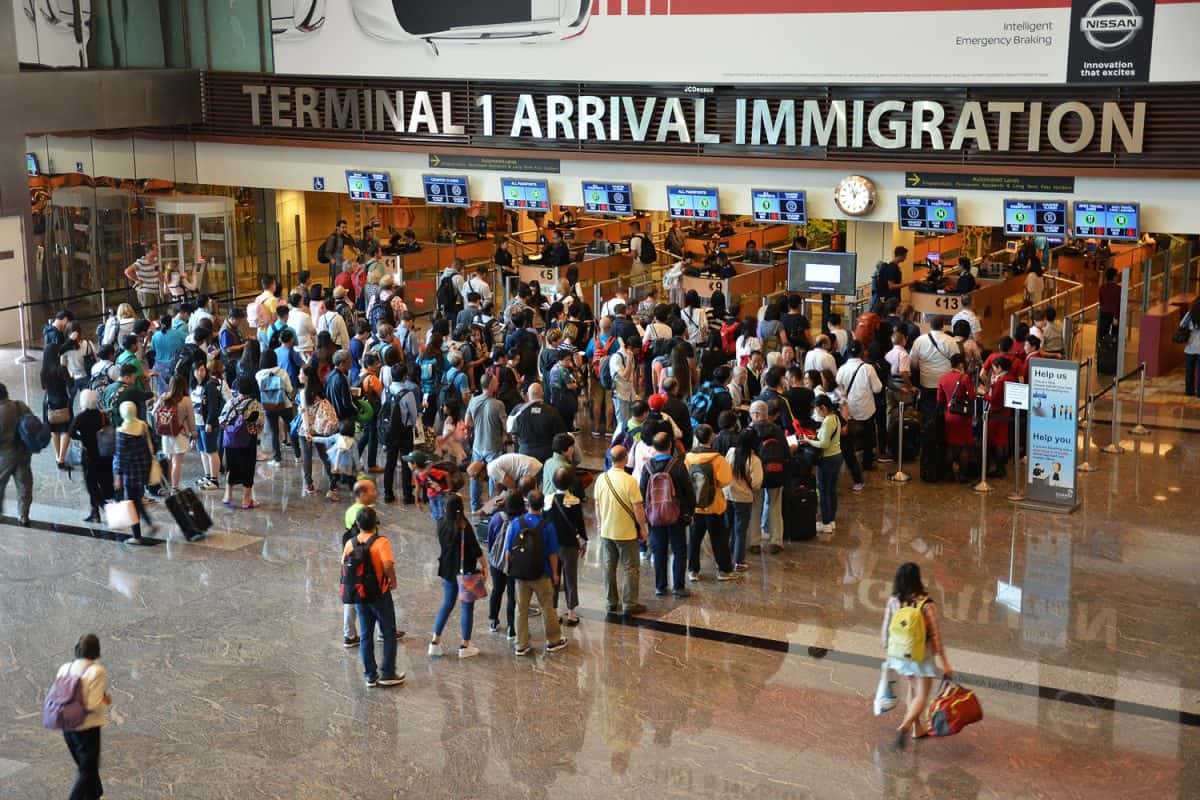Travelers enter immigration control at Changi International Airport in Singapore.