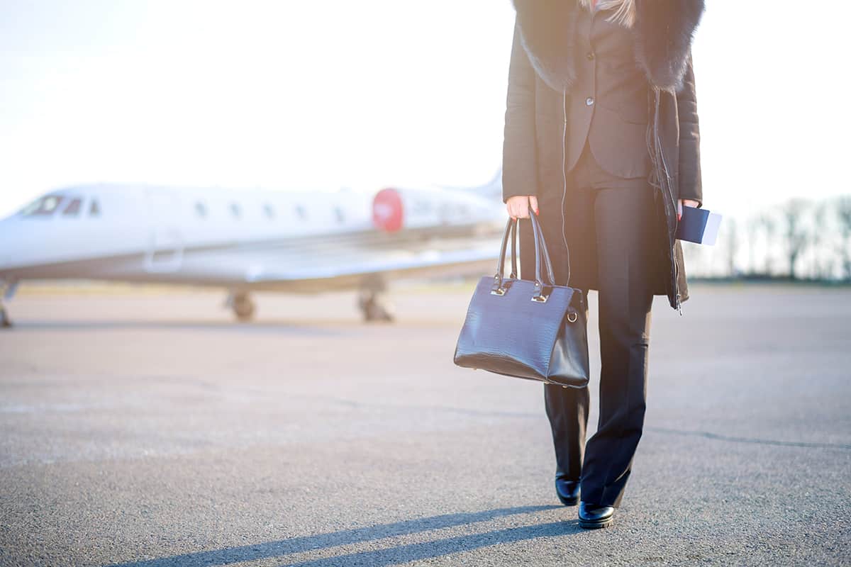 Young businesswoman leaving private jet airplane