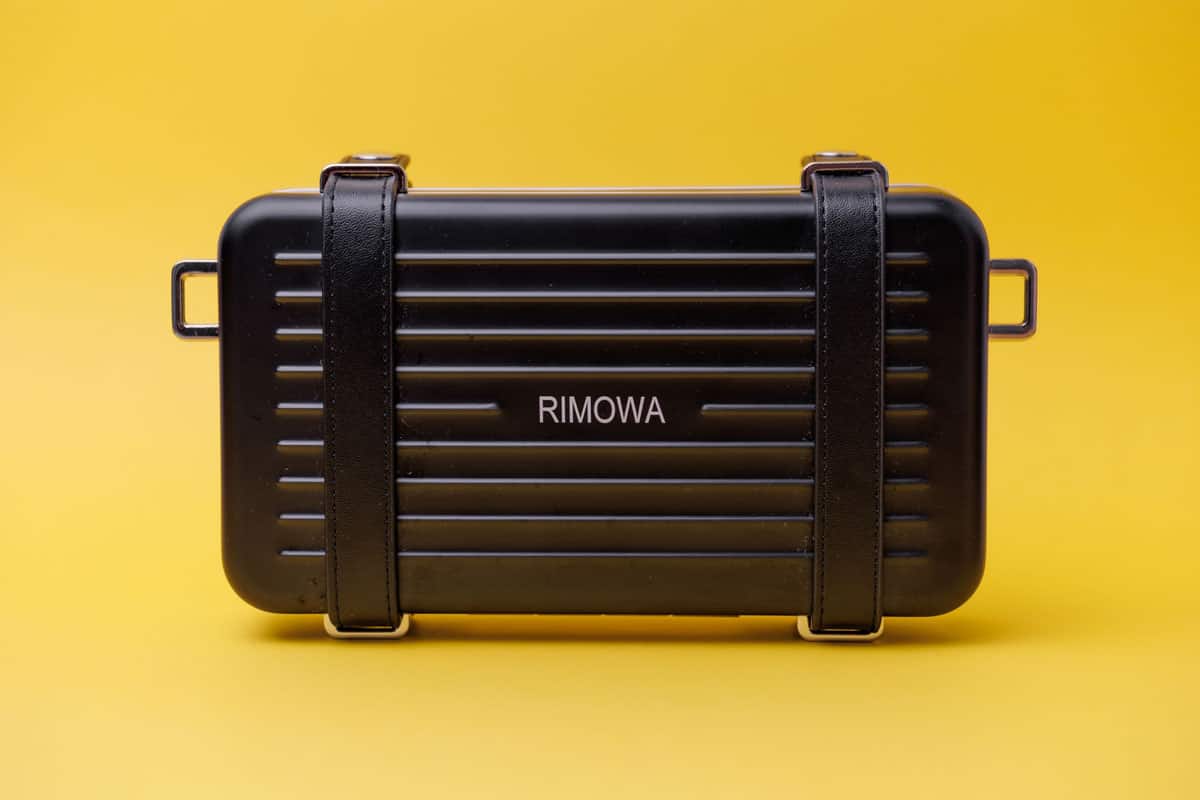 black rimowa luggage on a yellow background